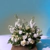 White floral arrangement with a clear glass cross centerpiece