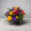 Colorful mixed bouquet in a square vase with a butterfly decoration