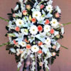 Standing floral spray with white lilies, daisies, and peach roses