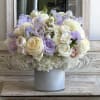 Pastel bouquet of white and lavender flowers in a ribbed vase