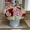 Bouquet of red and pale pink roses with white orchids in a ribbed glass vase
