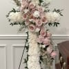 Large standing cross of white blooms with blush-pink roses, lush greenery on
