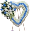 Heart-shaped floral wreath on an easel with blue and white flowers
