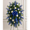 Blue and white funeral wreath with a ribbon on a stand