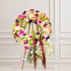 Large floral wreath on a wooden easel with cascading flowers