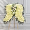 Large white rose funeral spray on an easel with greenery