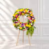 Colorful floral wreath on a wooden easel with roses and daisies