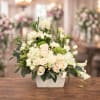 Cream and blush floral arrangement in a white rectangular vase