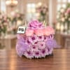 Purple and pink floral arrangement with candles on a table
