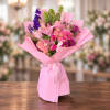 Pink bouquet with lilies, roses, tulips, and purple flowers wrapped in pink paper