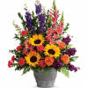 Colorful mixed bouquet in a gray vase with sunflowers, roses, and tall purple blooms