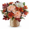 Bouquet of peach roses and white flowers in a gold woven vase