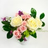 Pink and cream roses in a white vase with purple blooms