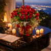 Red rose arrangement in a glass vase with candles on a piano