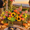 Large floral centerpiece with sunflowers, roses, and pink snapdragons in a wooden box