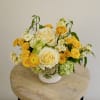 Yellow and white floral arrangement in a white vase
