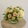 Bouquet of peach and cream roses in a clear glass vase