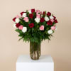 Bouquet of red, pink, and white roses in a clear glass vase