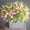 Pink tulips arranged in a square gray vase