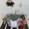 Succulent arrangement in a white pumpkin with an owl topper and brass candle holder