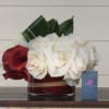 White and red roses arranged in a low glass vase