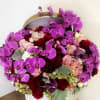 Designer arrangement of purple orchids, red roses and antique hydrangeas! 