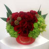 Red roses and green hydrangeas in a red round box