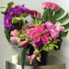 Orchids, roses hydrangea, cymbidiums and calla lilies beautifully arranged in cylinder black
