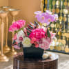 This modern arrangement of lavender and pink flowers is sure to delight.