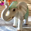 Decorative carved elephant figurine with green painted accents