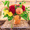 Mixed bouquet in a terracotta pot with yellow roses and red blooms
