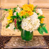 Yellow sunflowers and white hydrangeas in a glass vase