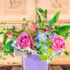 Pink roses and blue hydrangeas in a lavender vase