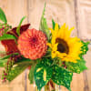 Bouquet with a coral dahlia and yellow sunflower in a glass vase