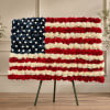 Floral arrangement shaped like the American flag on an easel