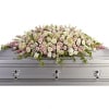 White and blush floral spray on a silver casket