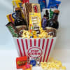 Popcorn bucket filled with candy bars and two soda bottles