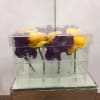 Purple and yellow flowers arranged in a clear acrylic box