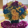Bouquet of yellow roses, purple tulips, and blue hydrangeas in a vase