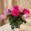 Pink and lavender roses arranged in a clear glass vase