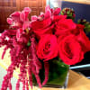 Red roses and pink orchids in a square glass vase