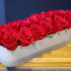 Long white box filled with red roses