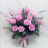 Pink roses arranged in a clear vase with eucalyptus foliage