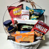 Gift basket filled with assorted snack bags, cookies, and candy in a white basket