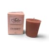 Pink boxed votive candle beside a brown candle