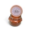 Orange scented candle in a glass jar with a round lid