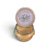 A scented candle in a glass jar with a round lid label