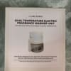 Boxed Claire Burke electric fragrance warmer unit on patterned fabric