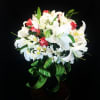 Bouquet of white lilies and red roses with a green ribbon bow