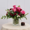 Pink and red roses arranged in a clear glass vase